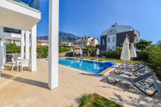 Hisarönü Villa Şans’ın 10 x 5 metre özel yüzme havuzu, güneşlenme alanı ve modern villa dış cephe görünümü.