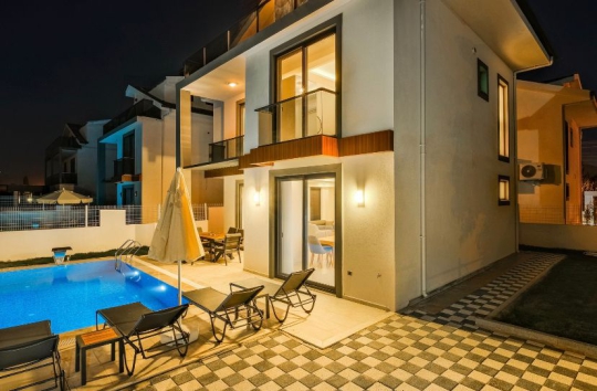 Villa Ubud 4’ün gece görünümü, aydınlatılmış modern dış cephesi, özel havuzu ve havuz başı dinlenme alanlarıyla şık bir atmosfer sunmaktadır.