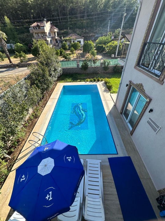 Marmaris Villa Diamond 2’nin özel yüzme havuzu, şezlong ve şemsiyelerle düzenlenmiş havuz başı güneşlenme alanı.