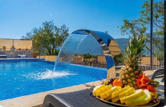 Villa Melodi’nin doğa manzaralı özel yüzme havuzu, şelale detayı ve havuz başında hazırlanan romantik tatil konsepti.