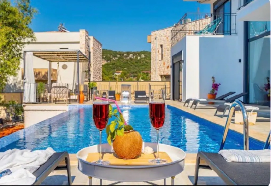 Kaş Çukurbağ Villa Melodi’nin özel havuzu, lüks dış yaşam alanı ve havuz başında hazırlanan şık meyve sunumu.