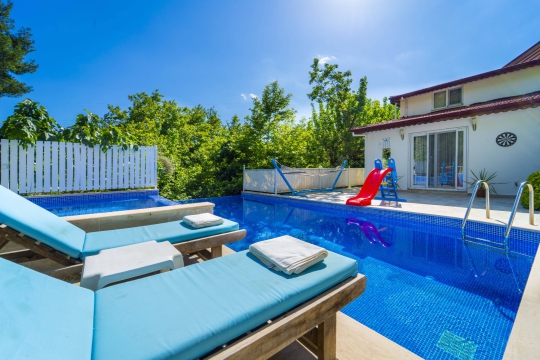 Korunaklı havuz alanı ve konforlu şezlonglarıyla Villa Tüzel, balayı çiftleri ve aileler için özel bir tatil deneyimi sunmaktadır.
