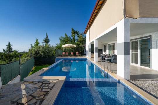 Seydikemer Yakaköy Villa Apilla’nın özel yüzme havuzu, modern villa cephesi ve korunaklı havuz başı alanı.