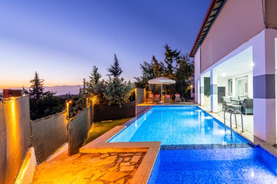 Villa Apilla’nın gün batımında özel yüzme havuzu, modern dış cephesi ve doğa içerisinde huzurlu tatil atmosferi.