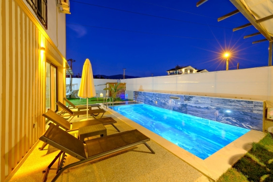 Akşam ışıklarıyla aydınlanan Villa Grandy havuzu, jakuzili ve özel tasarımlı yapısıyla lüks tatil deneyimi sağlar.