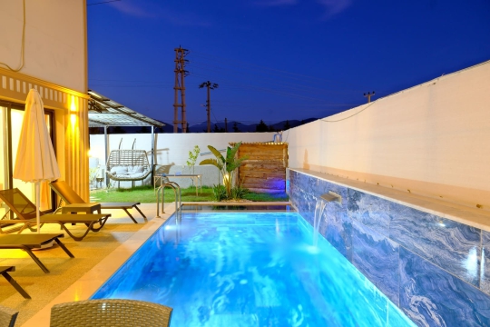 Villa Grandy’nin şık mimarisi ve havuz başı oturma alanı, modern tatil konsepti ile öne çıkmaktadır.