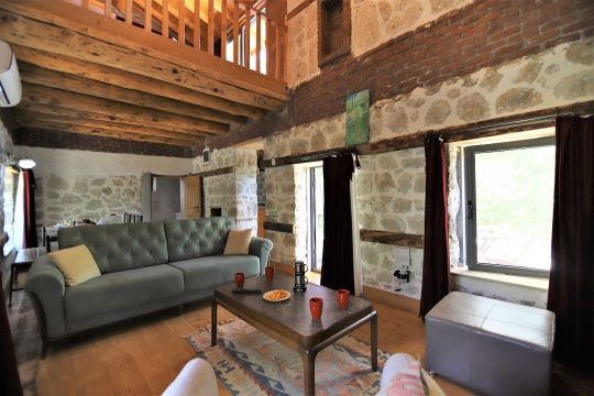 Villa Bekay taş duvarlı otantik salon tasarımı ve konforlu oturma grubu