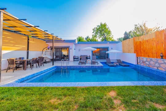 Villa Simos'un doğayla iç içe özel havuzu ve modern mimarisiyle Kalkan Yeşilköy'de keyifli bir tatil deneyimi sunuyor.