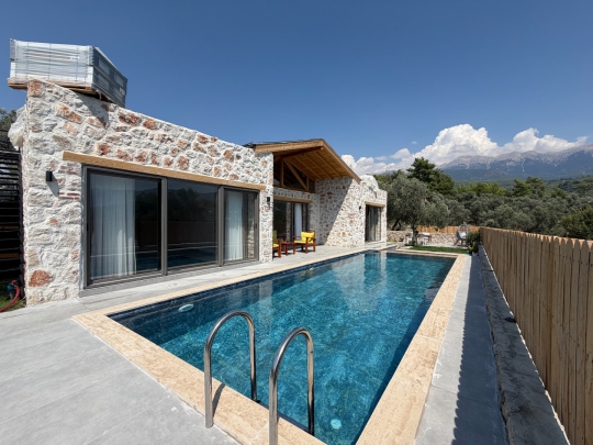 Doğal taş villa ve özel havuz görünümü, geniş bahçe alanı ve sakin atmosferiyle keyifli bir tatil deneyimi sunuyor.