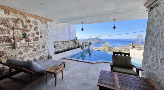 Gölgelikli havuz terasından panoramik Kalkan ve deniz manzarası