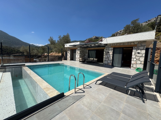 Seydikemer’de kiralık Villa Karahan’ın geniş yüzme havuzu ve güneşlenme terası ile keyifli tatil imkanı.