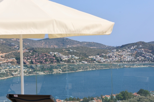 Villa Zima 1’in terasından görülen eşsiz Kalkan deniz manzarası, masmavi koyları ve doğasıyla etkileyici bir tatil atmosferi oluşturmaktadır.