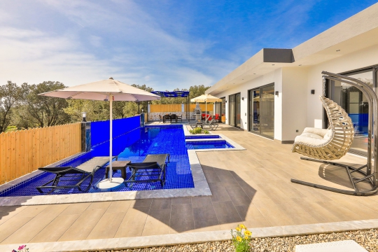 Özel havuz başında konforlu oturma grubu ile dinlenme köşesi.