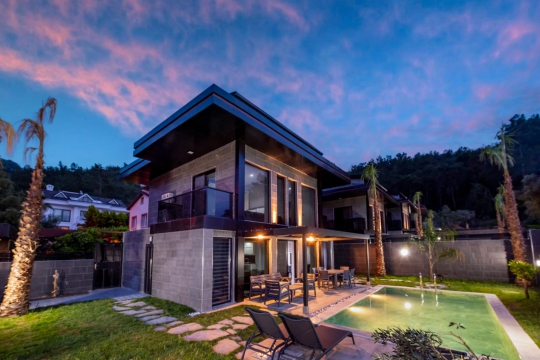 Modern mimarisi, gölgelikli veranda alanı ve özel yüzme havuzuyla Villa Anka 3'ün havuz terası görünümü.