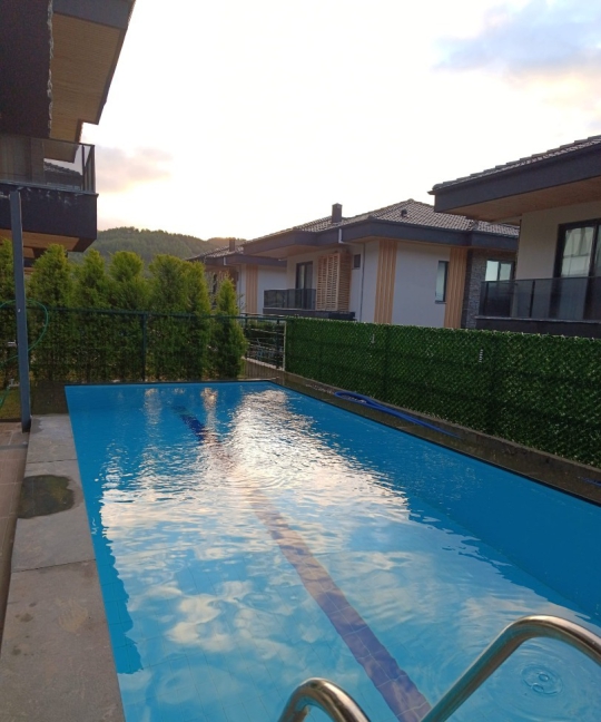 Havuz başında, gün boyu güneşin ve temiz havanın tadını çıkarabileceğiniz modern veranda.