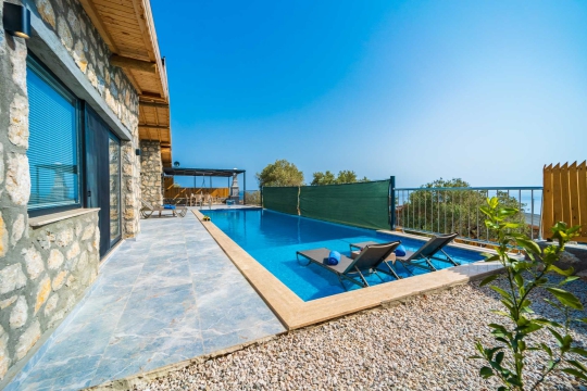 Taş yapı dokusu ve modern çizgileriyle Villa Kumsal 1’in girişi ve dış cephe detayları.