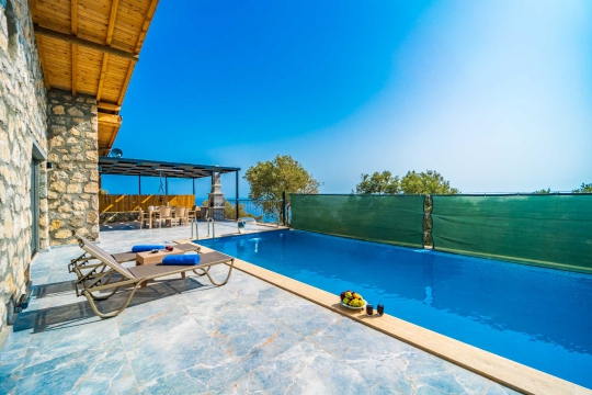 Taş yapı dokusu ve modern çizgileriyle Villa Kumsal 1’in girişi ve dış cephe detayları.