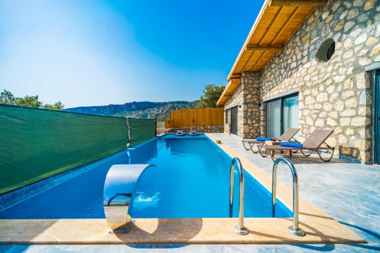 Taş yapı dokusu ve modern çizgileriyle Villa Kumsal 1’in girişi ve dış cephe detayları.