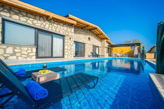 Havuz başından kesintisiz deniz manzarası ve villa dış cephesi.