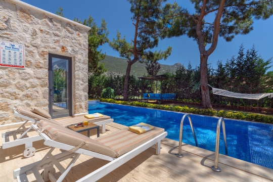 Kalkan lüks kiralık villa şezlongları, havuz terası ve doğa manzaralı güneşlenme alanı.