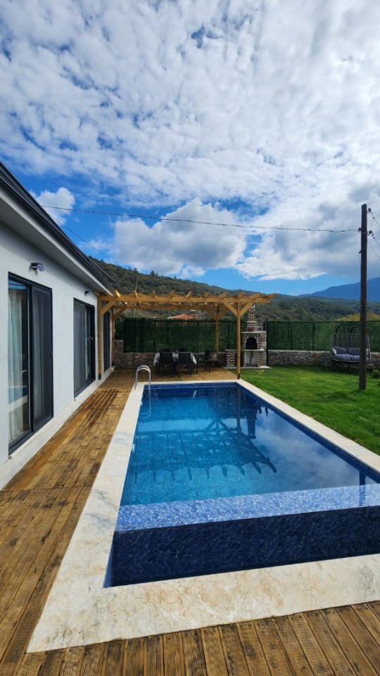 Yarı korunaklı yapısıyla mahremiyet sunan güneşlenme alanı ve havuz keyfi.