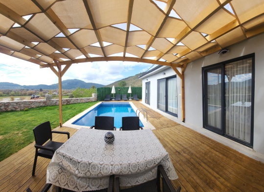 Pergola altındaki dış mekan yemek alanı ile keyifli akşam yemekleri.