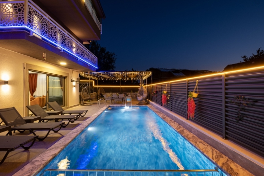 Gece ışıklandırmasıyla dikkat çeken Villa Pandora'nın özel havuzu ve lüks dış yaşam alanı.