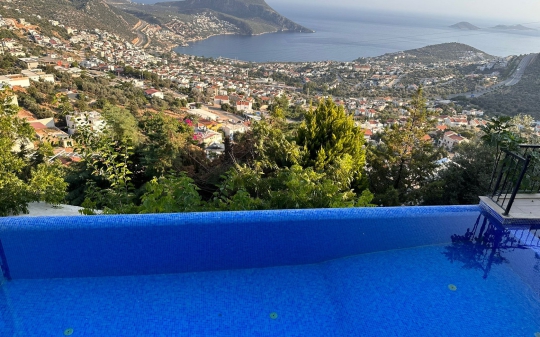 Üst açıdan infinity havuz ve büyüleyici Kalkan şehir/deniz manzarası