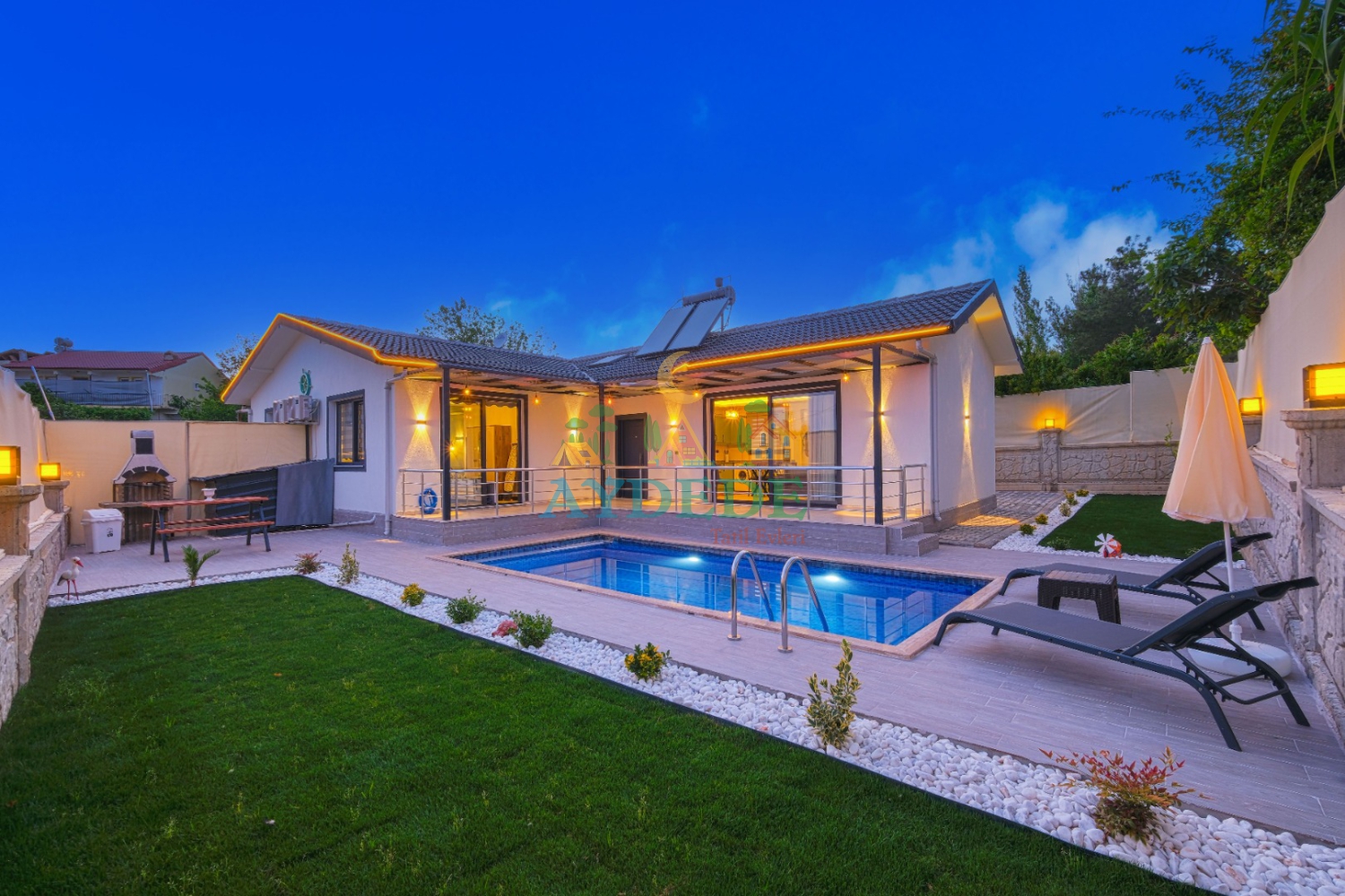 Villa Pra 2’nin akşam ışıklarında korunaklı özel havuz ve bahçe görünümü