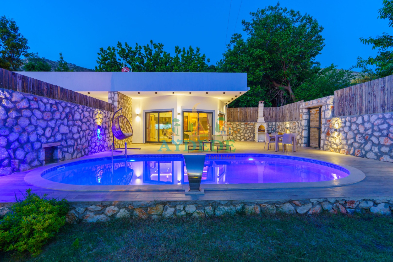 Villa Serter 2’nin gece aydınlatmalı korunaklı özel havuzu ve modern mimarisiyle öne çıkan dış cephe görünümü. Kalkan Üzümlü’de balayı çiftlerine özel huzurlu bir tatil sunmaktadır.