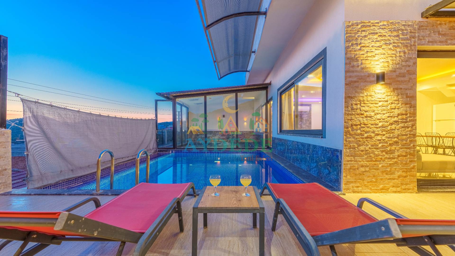 Villa Sidney 4 Kalkan Ulugöl’de korunaklı özel yüzme havuzu, şezlongları ve kapalı havuz alanıyla huzurlu balayı villası görünümü.