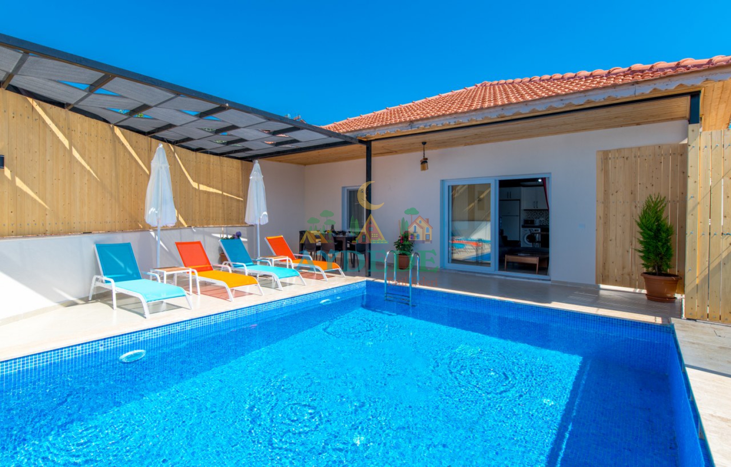 Villa Sidney 2 Kalkan Ulugöl’de korunaklı özel yüzme havuzu, şezlongları ve doğa manzarasıyla huzurlu balayı villası görünümü.