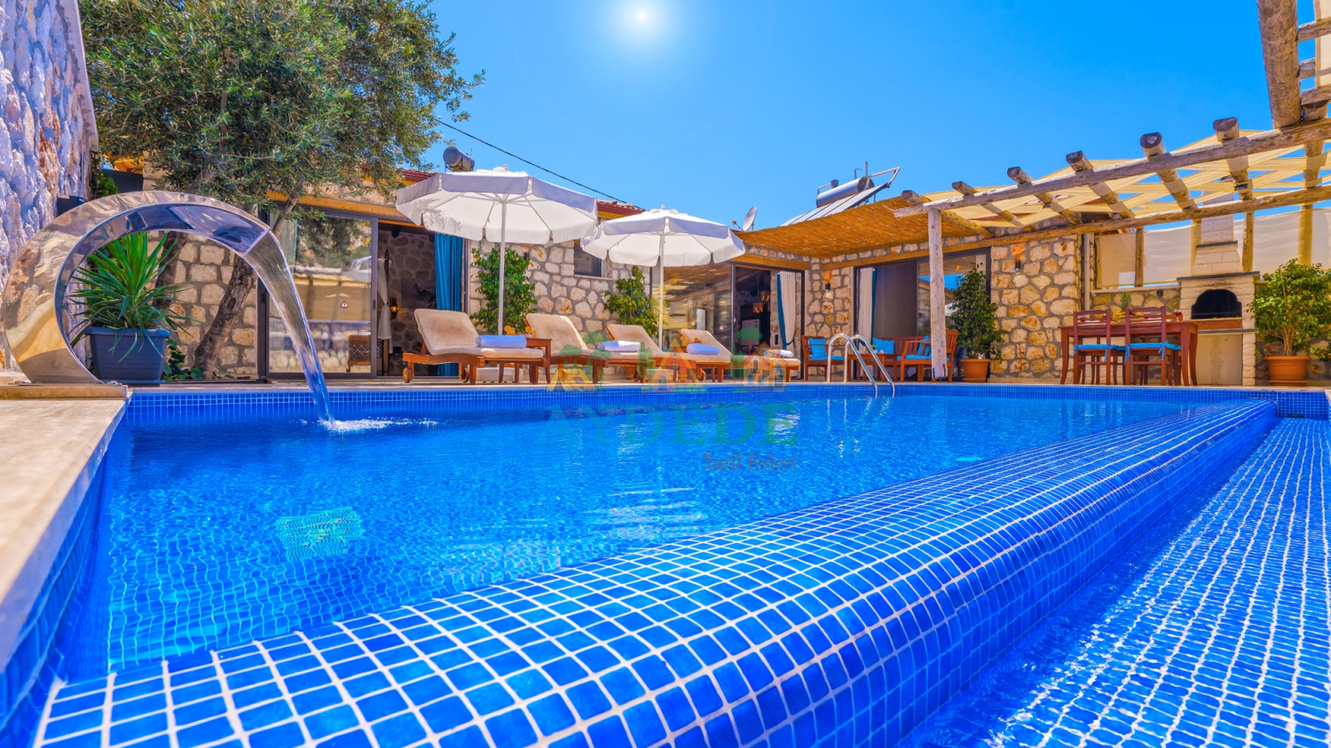 Kaş Kalkan Ordu mevkiinde otantik taş ve ahşap mimariye sahip Villa Lion 1'in mavi sulara sahip özel yüzme havuzu ve dış cephe görünümü.