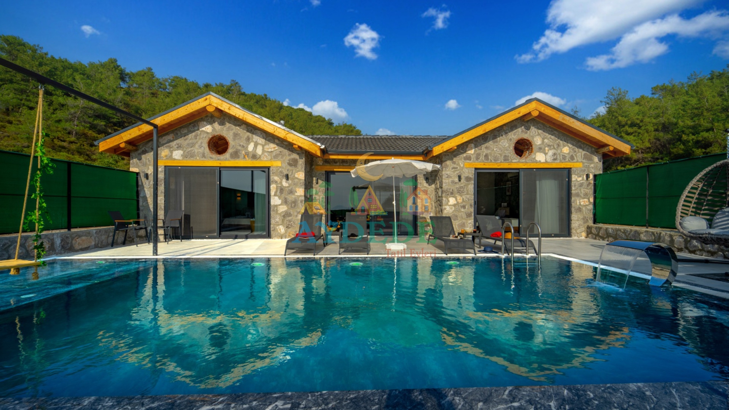 Villa New Star 2'nin korunaklı özel havuzu, modern taş mimarisi ve geniş bahçesiyle Fethiye Çalış'da lüks villa tatili.