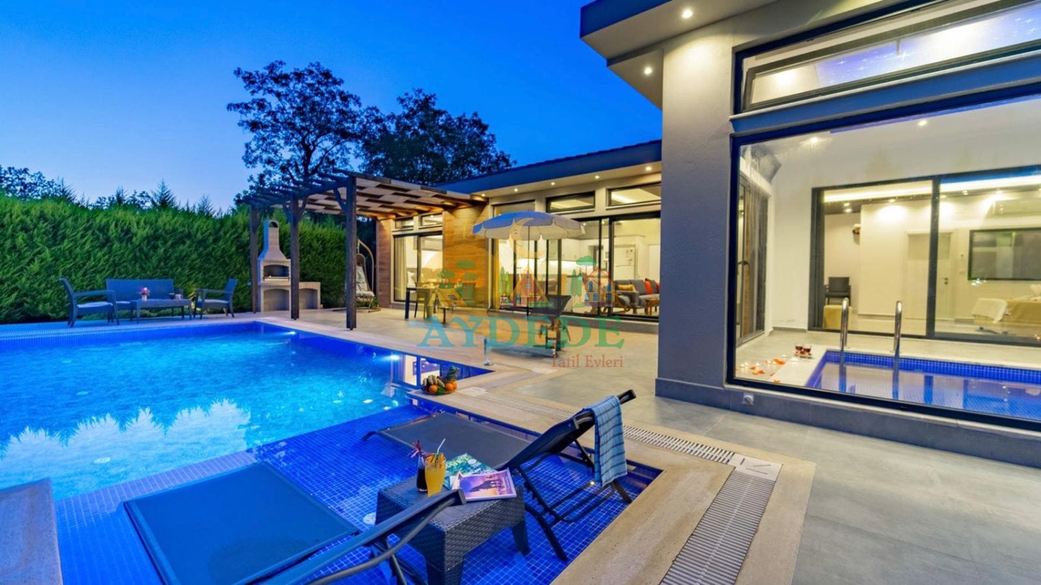 • Fethiye Kayaköy’de konumlanan Villa Marin’in korunaklı özel havuzu ve modern mimariye sahip lüks dış cephesi görünümü.