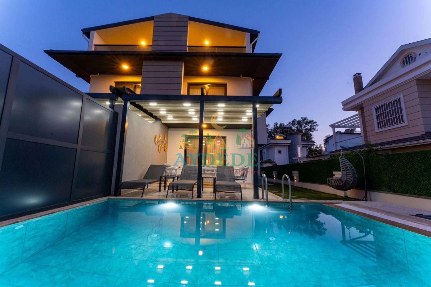 Fethiye Çalış’ta özel havuzlu Villa Menteş 2’nin modern dış mimarisi ve aydınlatmalı havuz alanı ile keyifli akşam atmosferi.