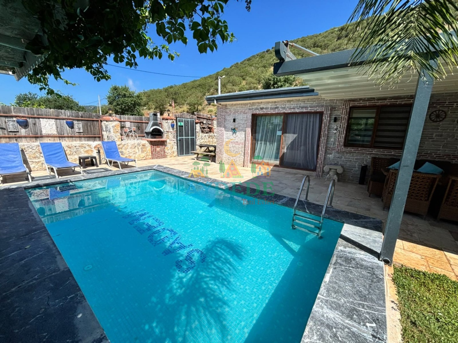 Villa Facer 2’nin özel yüzme havuzu ve taş mimarili dış cephesi. Fethiye Kayaköy’de muhafazakar kiralık villa tatili için ideal bir seçenektir.