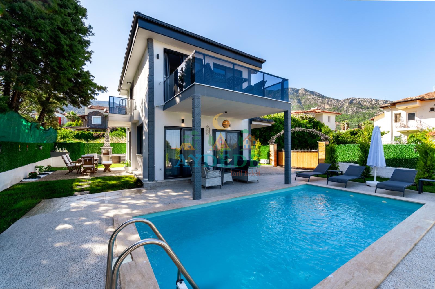 Villa Yeşilyurt'un Fethiye Ovacık'ta yer alan özel yüzme havuzu, modern mimarisi ve yemyeşil bahçesiyle huzurlu tatil atmosferi.