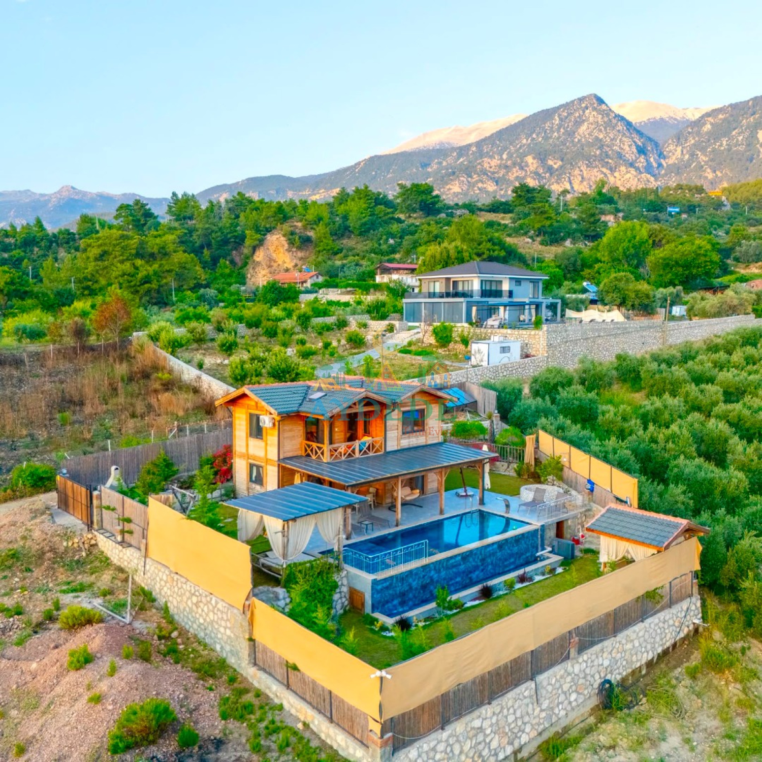 Villa Lamur'un Fethiye Yakaköy'de doğa manzarasına sahip ısıtmalı özel havuzlu ve geniş bahçeli genel görünümü.
