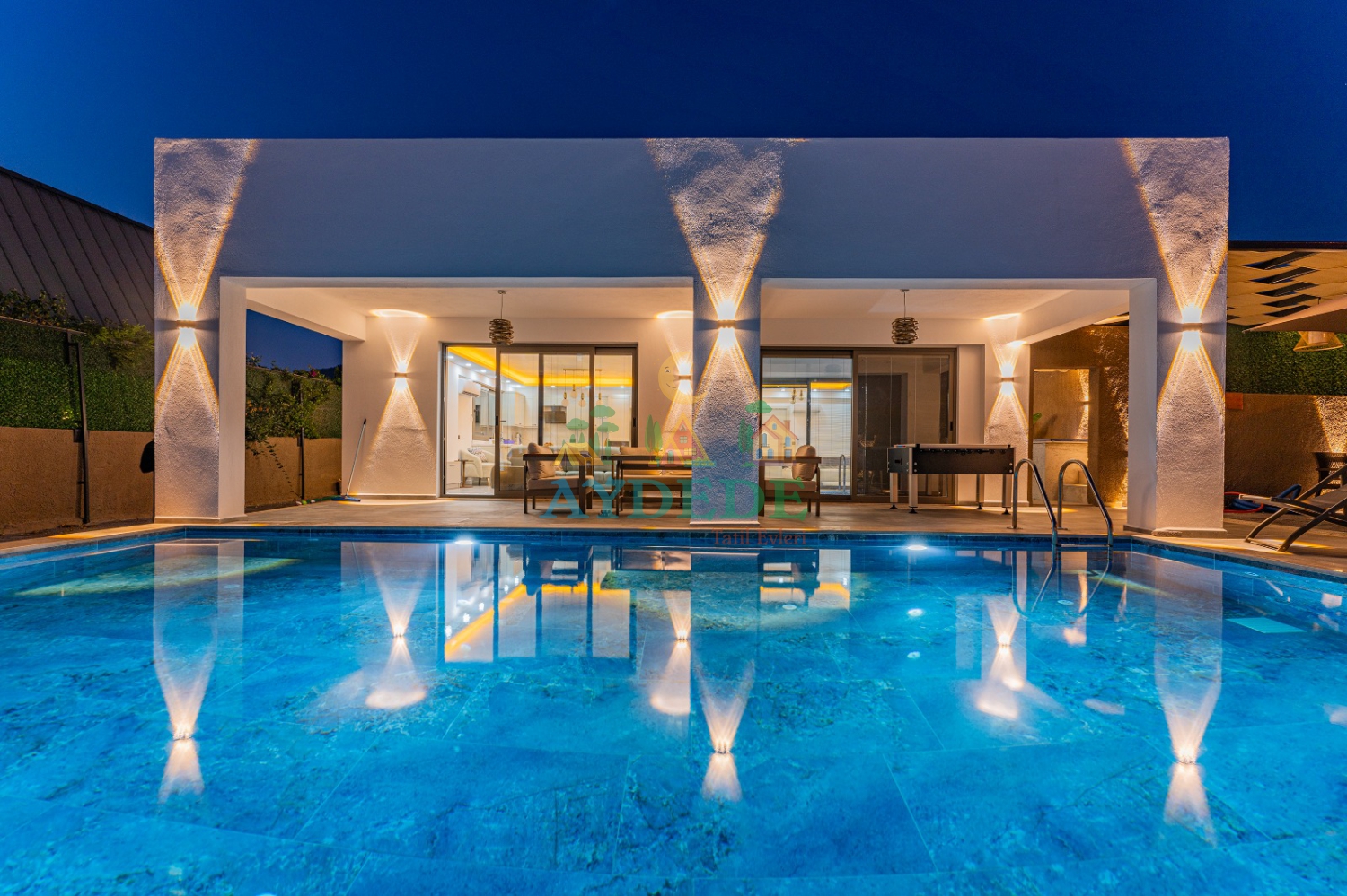 Villa Tommy'nin akşam aydınlatmalı geniş özel havuzu, kapalı ısıtmalı havuzu ve konforlu bahçesiyle Fethiye'de ayrıcalıklı tatil.
