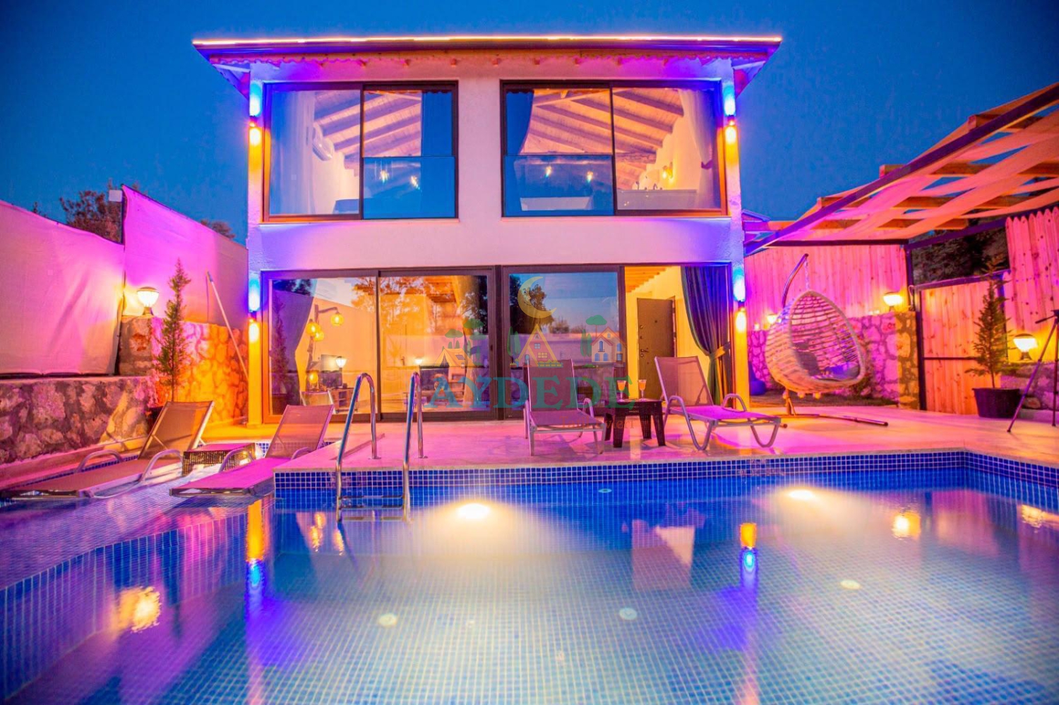 Villa Zois’in Kalkan Patara’daki gece görünümü; özel havuzu, modern mimarisi ve renkli aydınlatmalarıyla şık bir tatil atmosferi sunuyor.