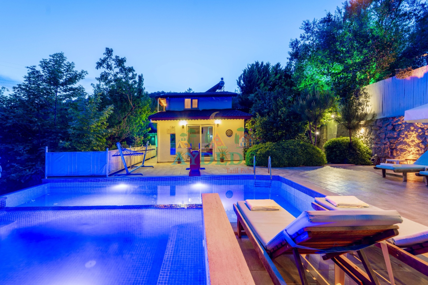 Villa Tüzel’in özel yüzme havuzu ve şık dış aydınlatmalarıyla akşam saatlerinde sunduğu huzurlu tatil atmosferi. Kalkan İslamlar’da muhafazakar kiralık villa seçeneği.