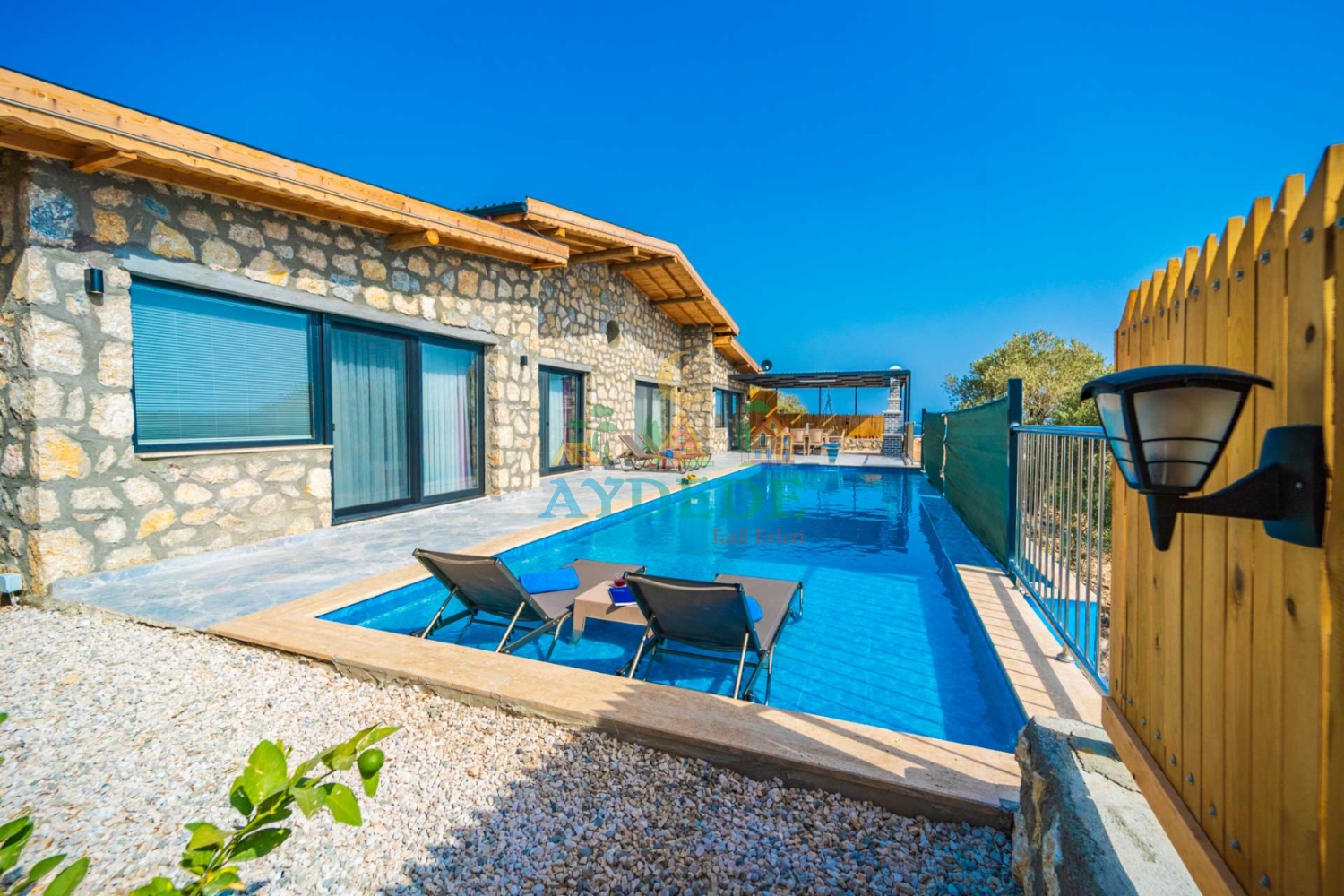 Villa Kumsal 1 taş mimarisi, özel yüzme havuzu ve geniş teras alanının panoramik görünümü.