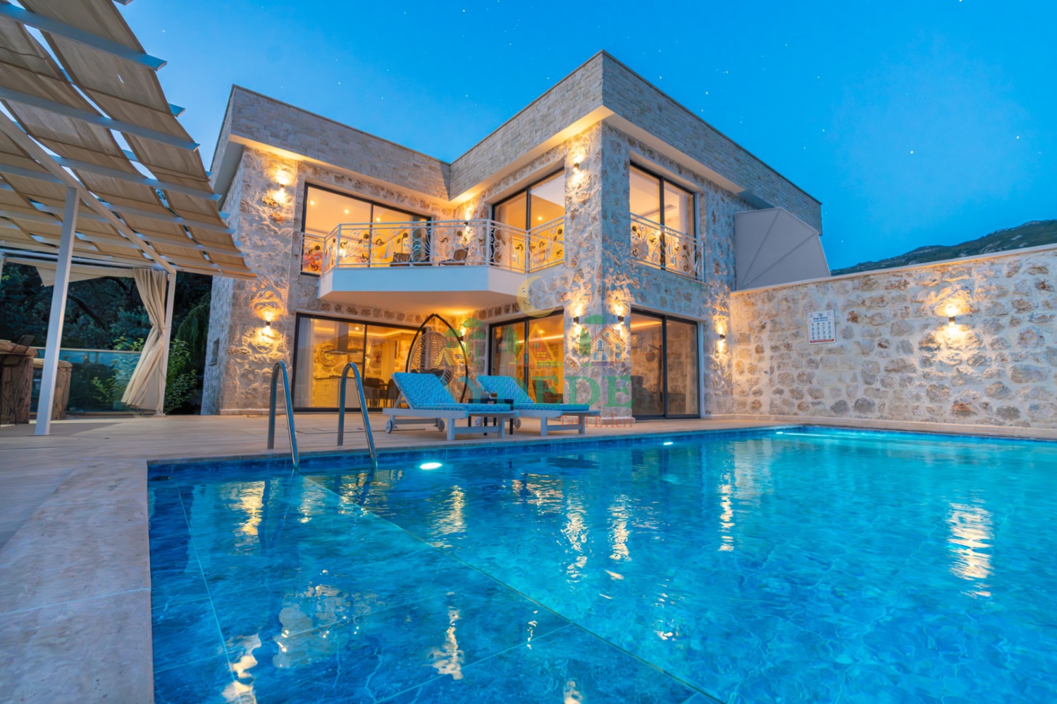 Kalkan İslamlar'da Villa Milenyum 1'in gece ışıklandırmalı taş mimarisi ve özel yüzme havuzu.