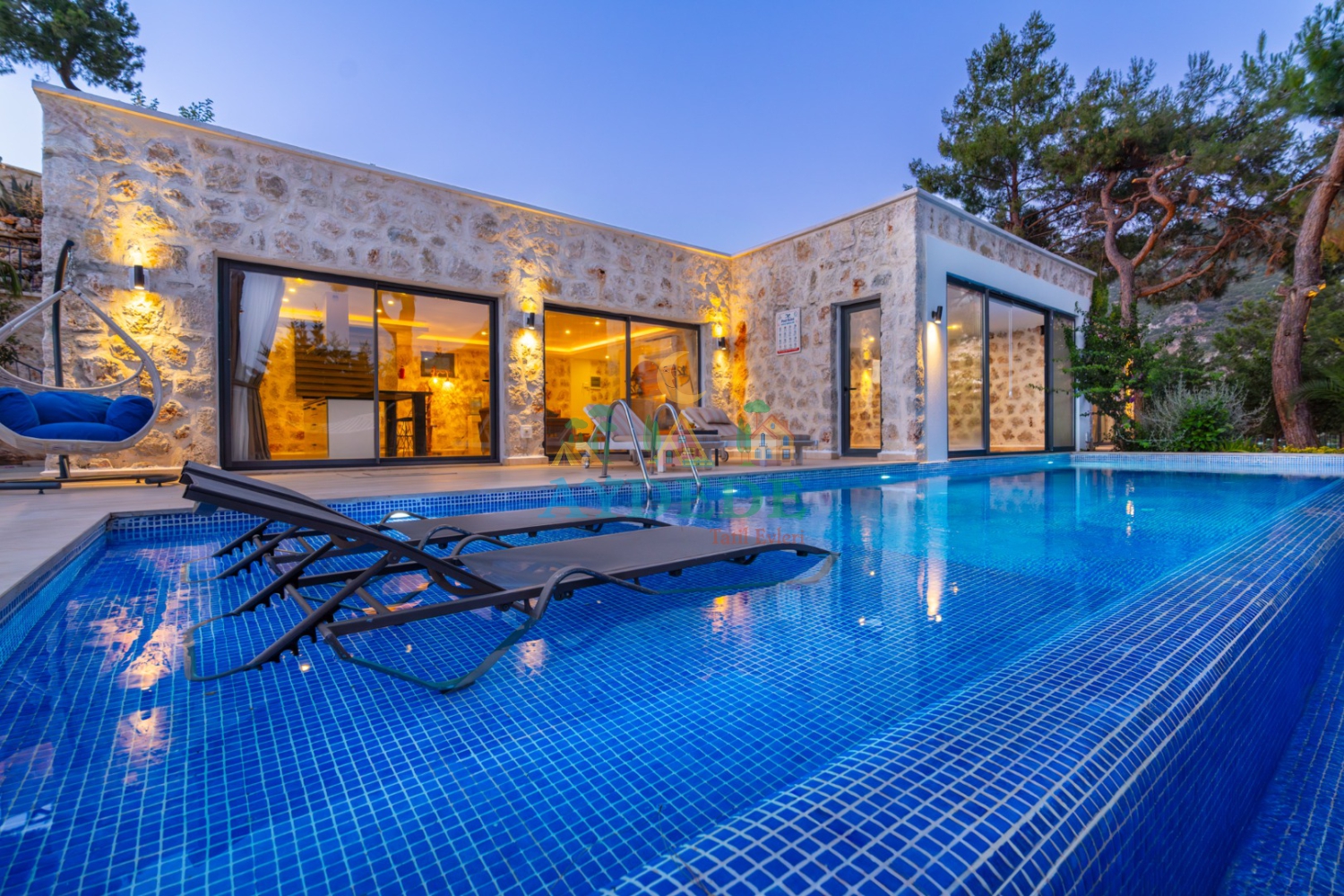 Kalkan İslamlar'da deniz manzaralı lüks kiralık villanın 11x4 metre büyüklüğündeki korunaklı özel yüzme havuzu ve taş mimarisi.