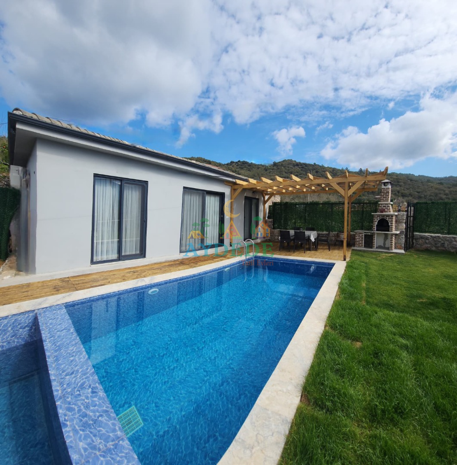 Villa Özgür’ün modern mimarisi ve geniş özel yüzme havuzuna genel bakış.