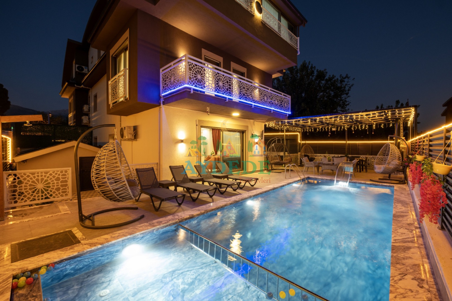Seydikemer Gerişburnu'nda bulunan Villa Pandora'nın akşam aydınlatmalı özel yüzme havuzu ve modern tripleks mimarisi.