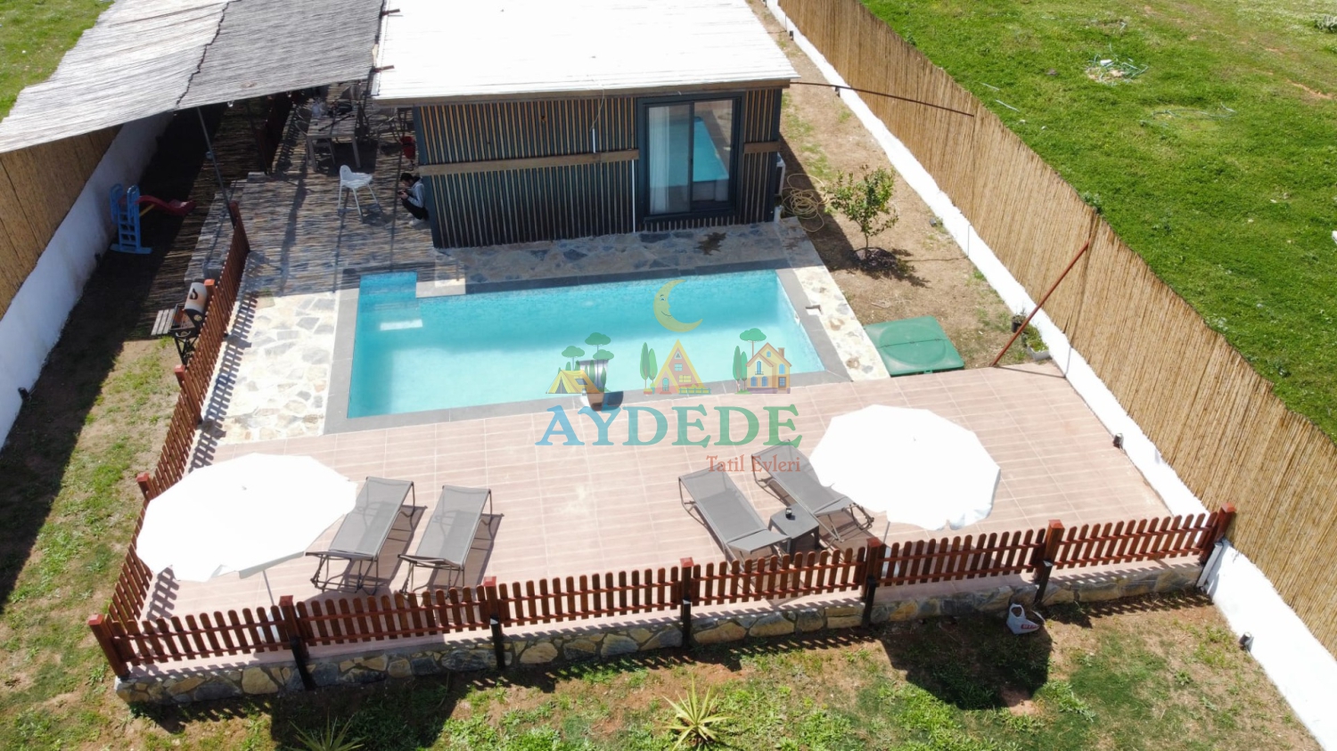 Seydikemer Gölbent'te doğa içinde yer alan Villa Simya 1'in korunaklı özel yüzme havuzu ve güneşlenme terasının havadan kuş bakışı görünümü.
